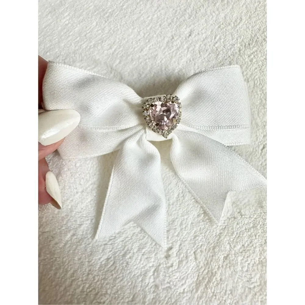 White bow hair clip with pink rhinestone heart ￼